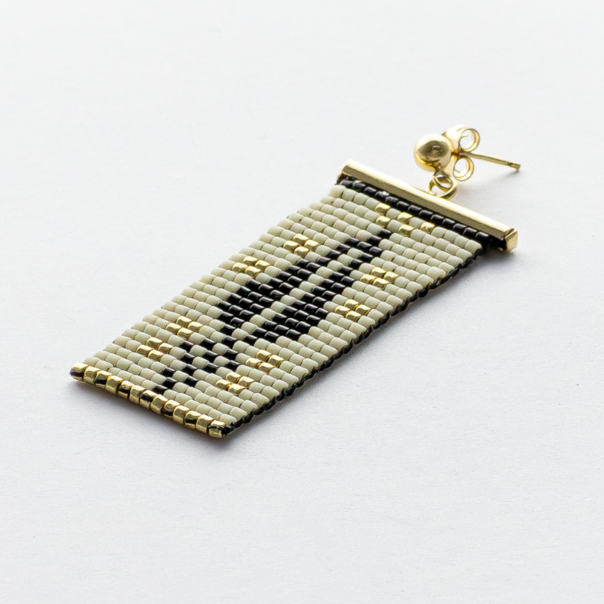Close-up of Cypress Earrings in dark cream - Highlighting black and gold beads