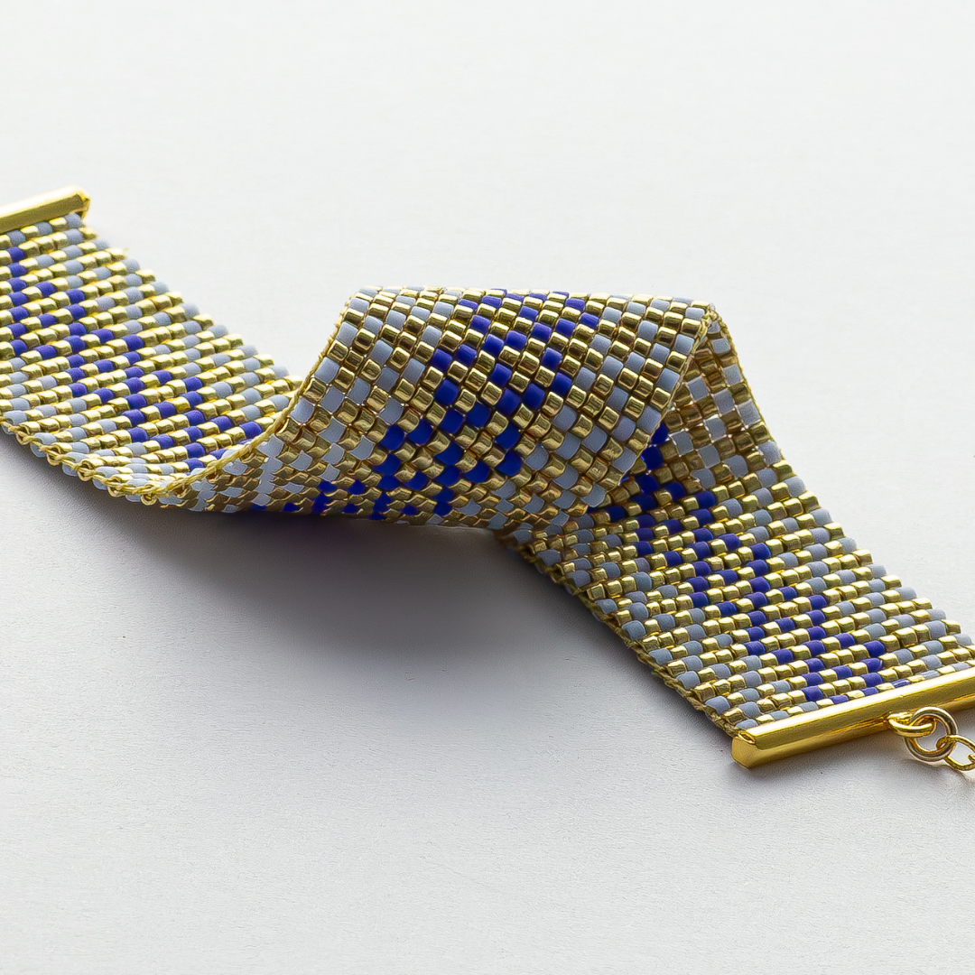 Syrian Inhabited Scroll bracelet showcasing a Tatreez pattern from Palestine in Blue and Gold