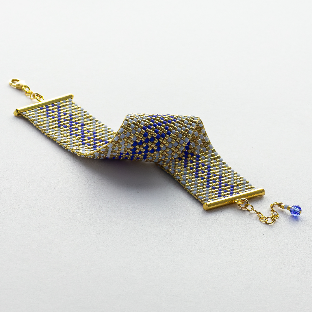 Syrian Inhabited Scroll bracelet showcasing a Tatreez pattern from Palestine in Blue and Gold