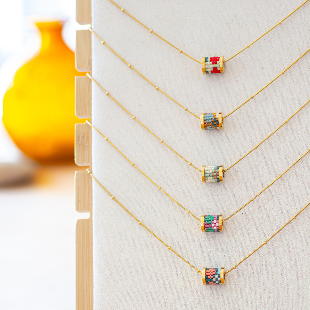 Five hand-beaded Tatreez sinsal tube necklaces in all colourways — bubblegum pink and evergreen, marigold and sea glass, cactus green and cedar brown, fennel and orange red, and evergreen and papaya. Miyuki glass beads on 304L stainless steel serpentine chokers.