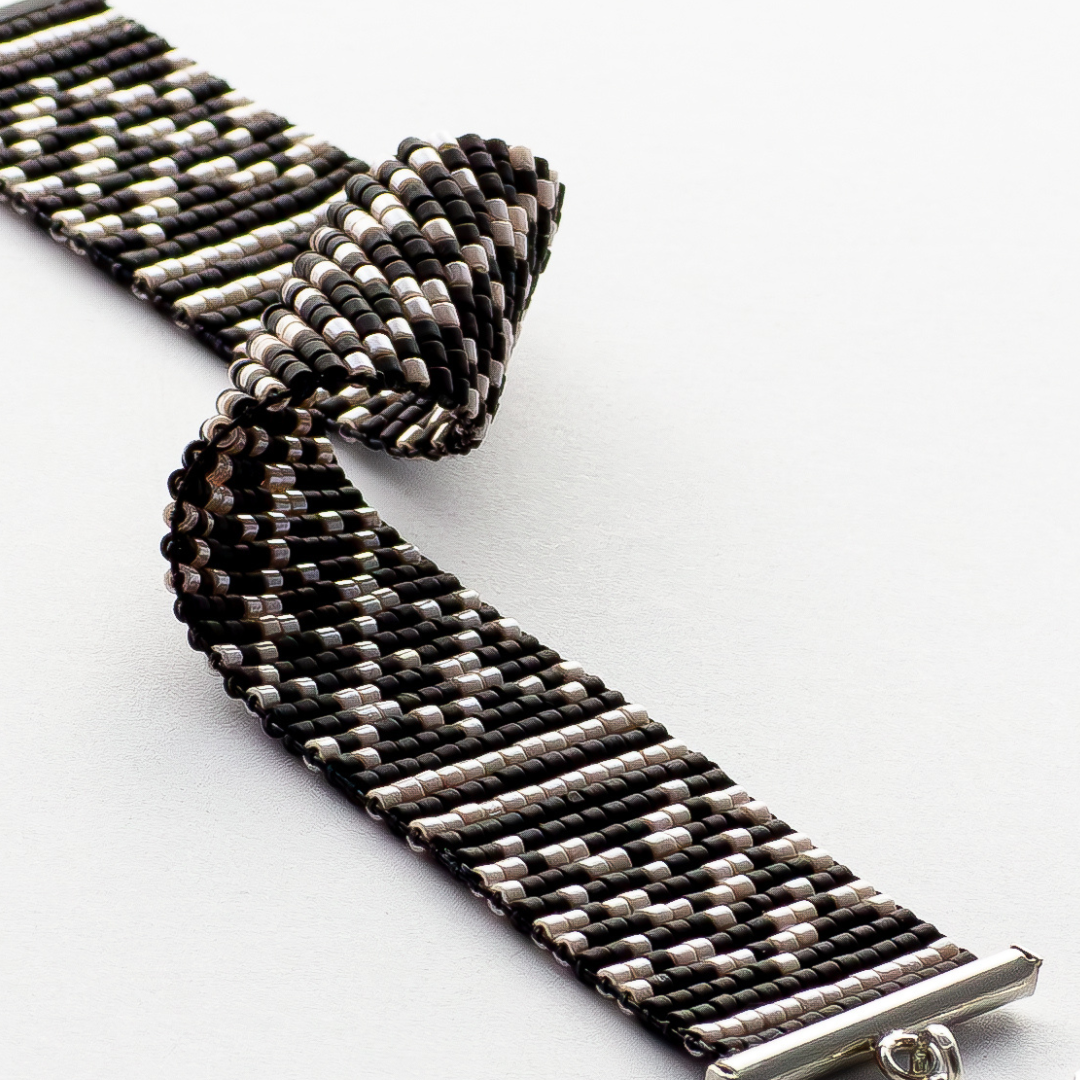 Black Kuffiyeh bracelet showcasing a Kuffiyeh in black and champagne beads