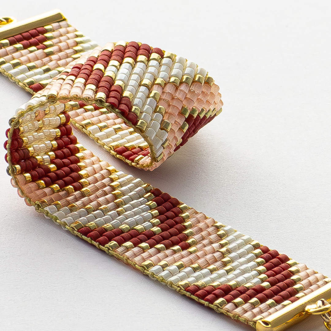 Sickles bracelet showcasing a Tatreez pattern from Ramallah in pink, red, gold and ivory