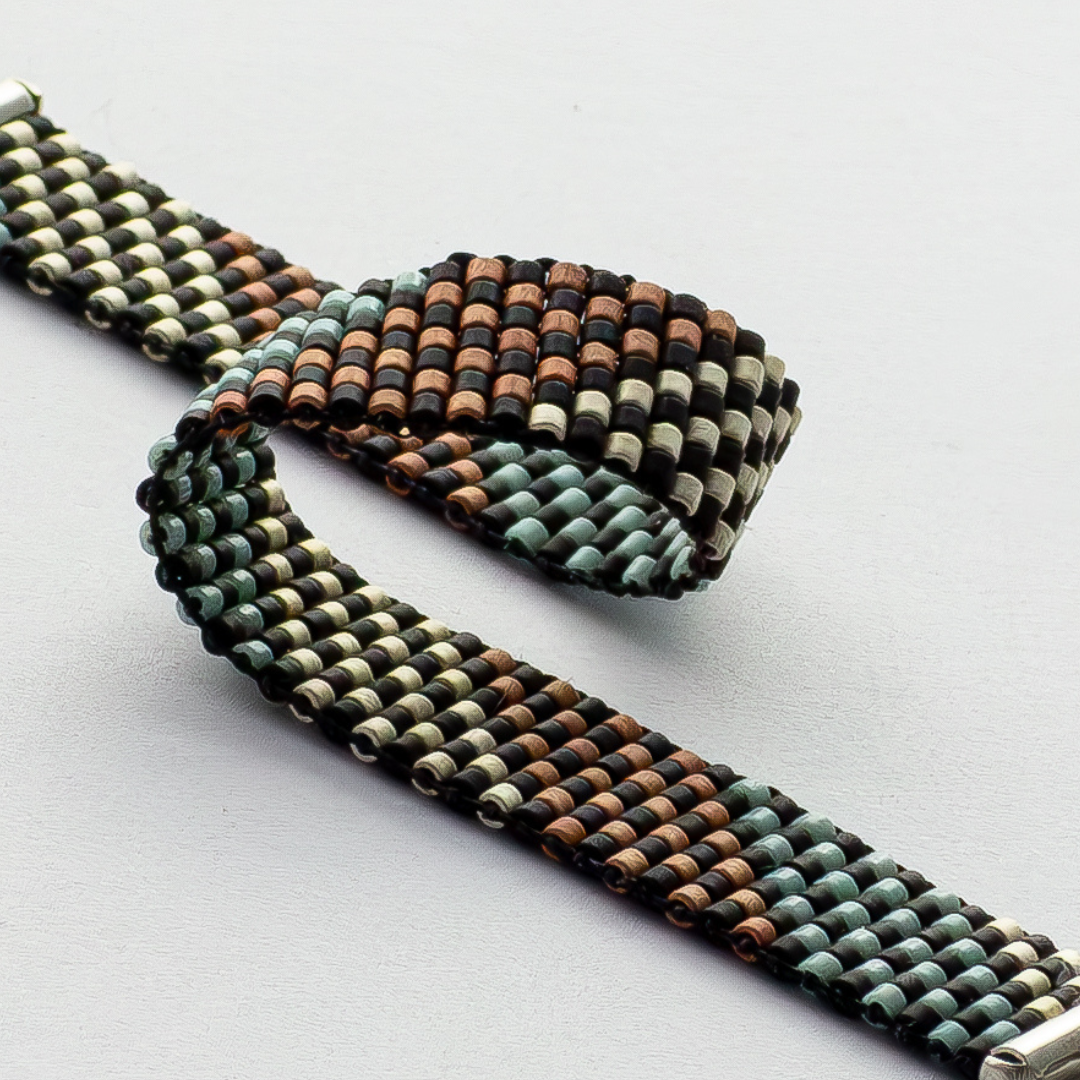 Feathers bracelet showcasing a Tatreez pattern from Al Khalil in rose blush, turquoise green, and matte silver.