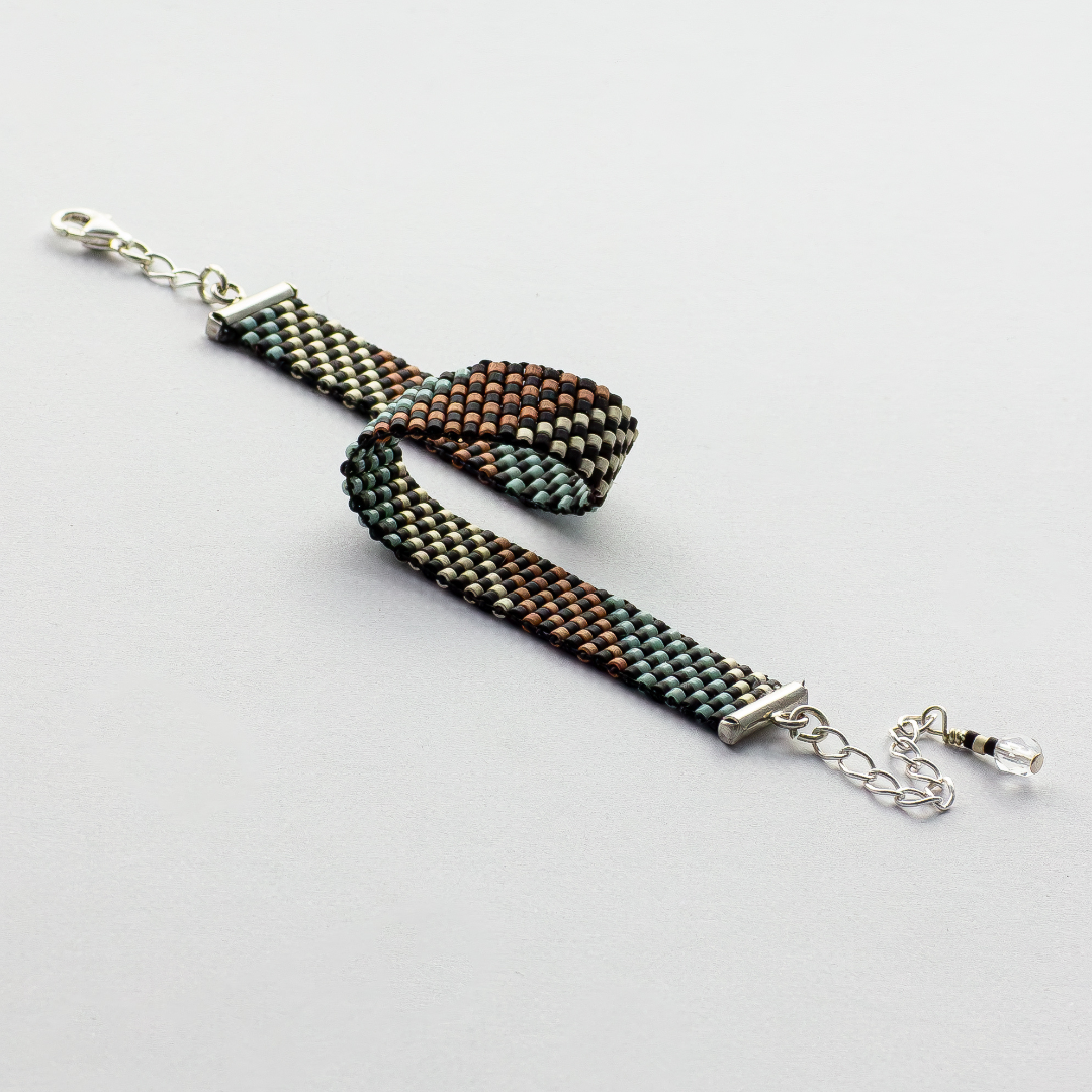 Feathers bracelet showcasing a Tatreez pattern from Al Khalil in rose blush, turquoise green, and matte silver.