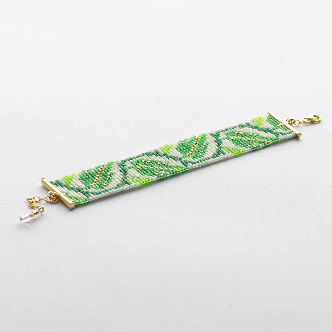 The leaf bracelet showcasing a Tatreez pattern from Ramallah in Green white and gold