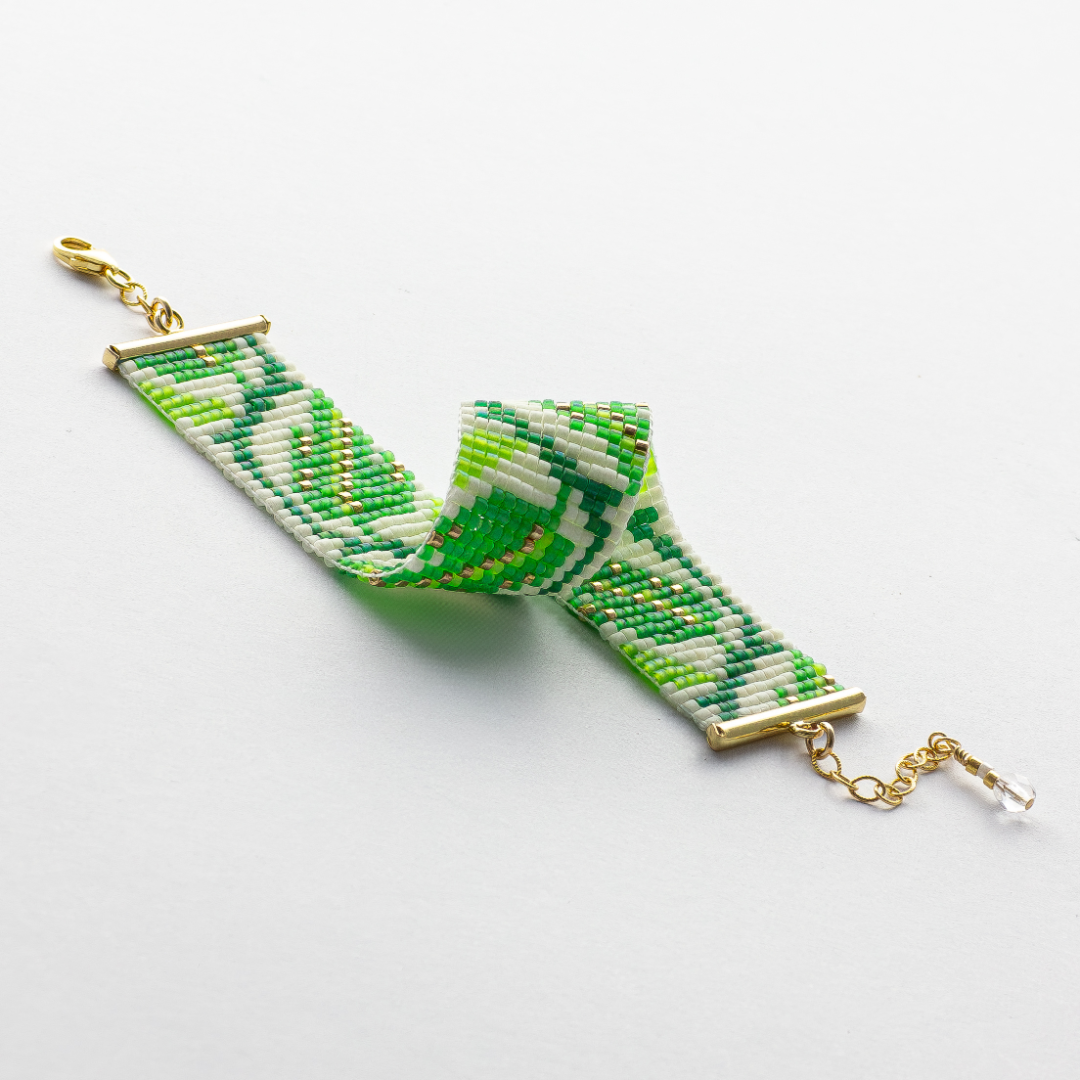 The leaf bracelet showcasing a Tatreez pattern from Ramallah in Green white and gold