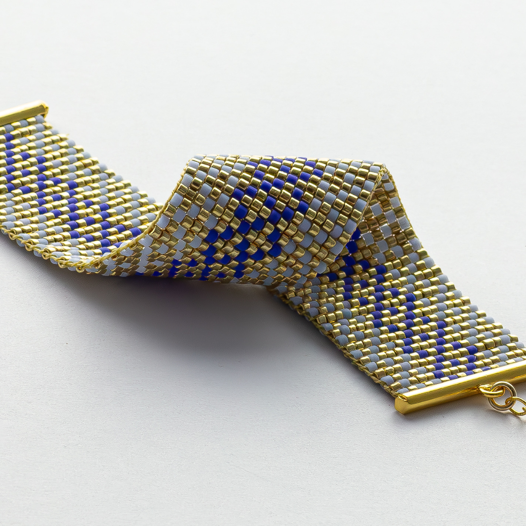 Syrian Inhabited Scroll bracelet showcasing a Tatreez pattern from Palestine in Blue and Gold 