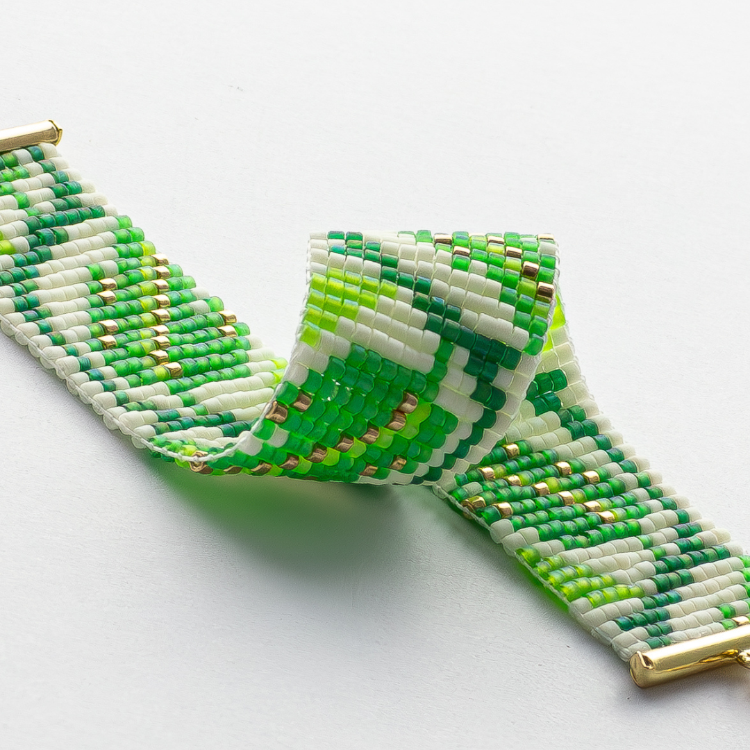 The leaf bracelet showcasing a Tatreez pattern from Ramallah in Green white and gold