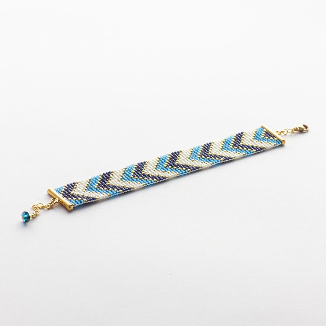 Sickles in Blue bracelet showcasing a Tatreez pattern from Al Khalil in rose blush, dark cream, and gold accents