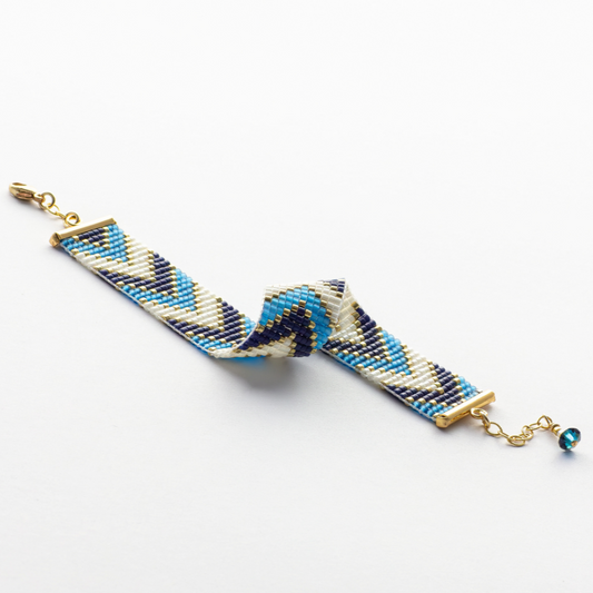 Sickles in Blue bracelet showcasing a Tatreez pattern from Al Khalil in rose blush, dark cream, and gold accents