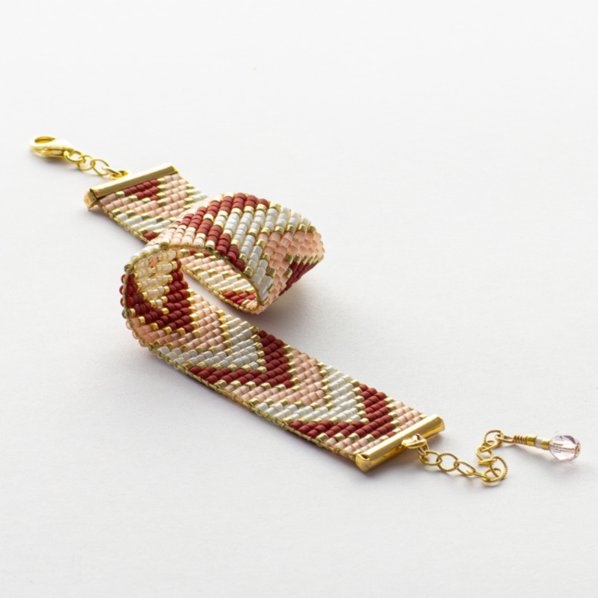 Sickles bracelet showcasing a Tatreez pattern from Ramallah in pink, red, gold and ivory