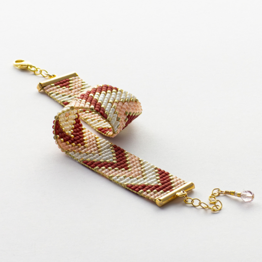 Sickles bracelet showcasing a Tatreez pattern from Ramallah in pink, red, gold and ivory