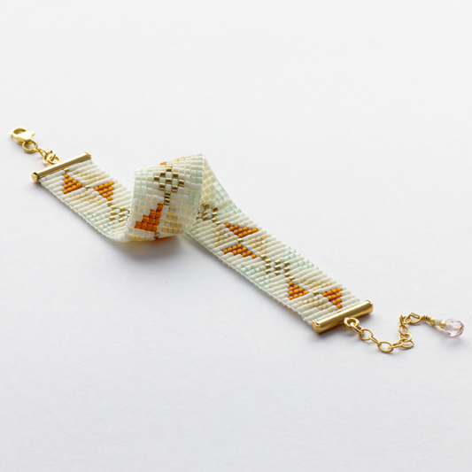 The Chain bracelet showcasing a Tatreez pattern from Yafa in honey opal, cream and mint green and gold