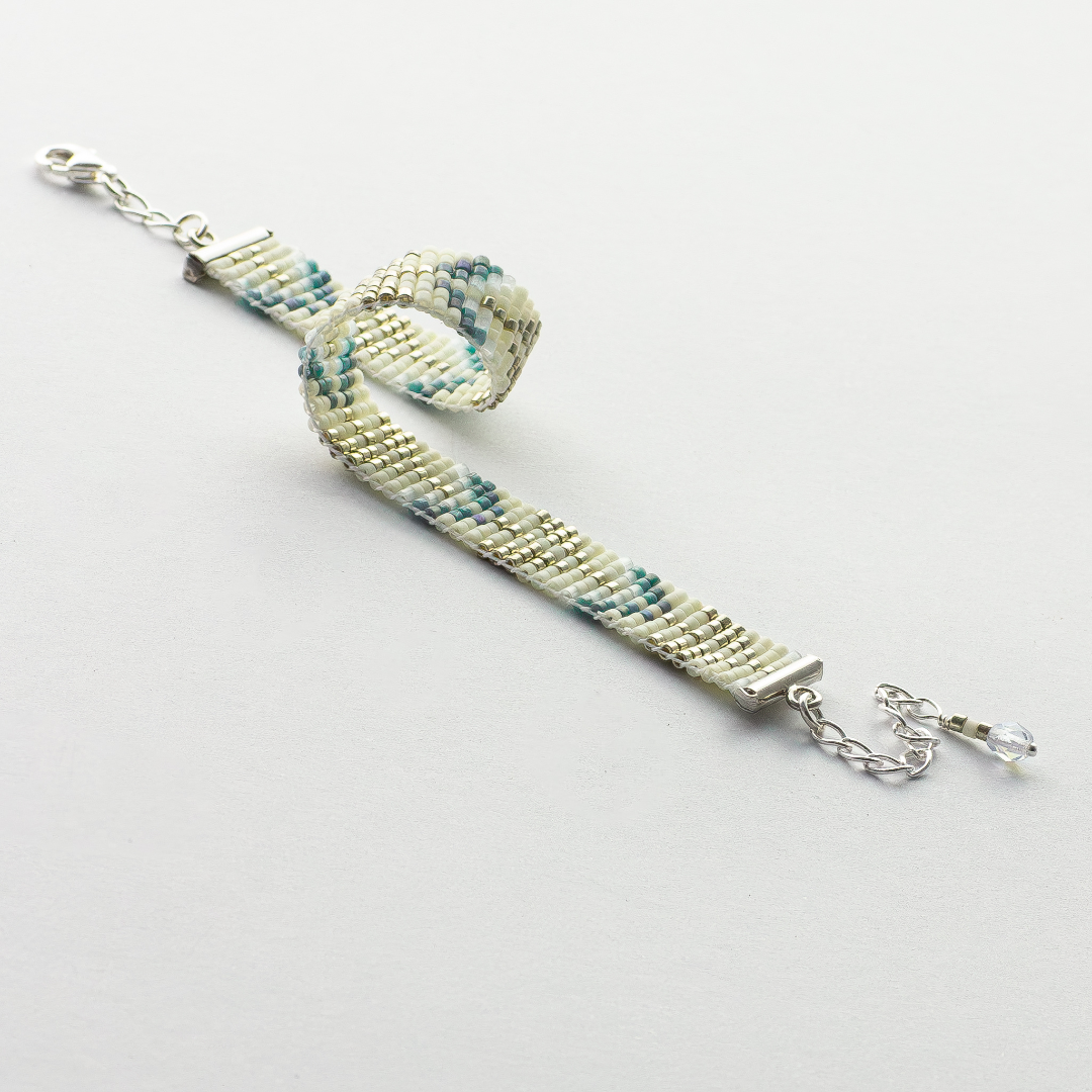 The Trees bracelet showcasing a Tatreez pattern from Esdud in Blue and Cream and Silver