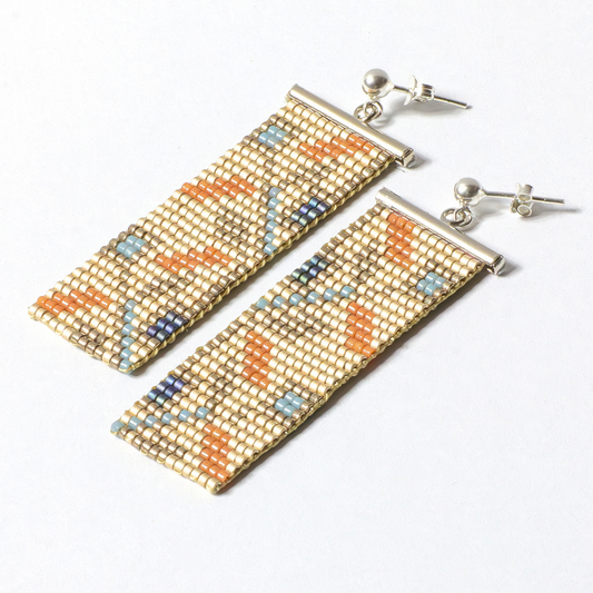 a pair of handwoven earrings on a white background
