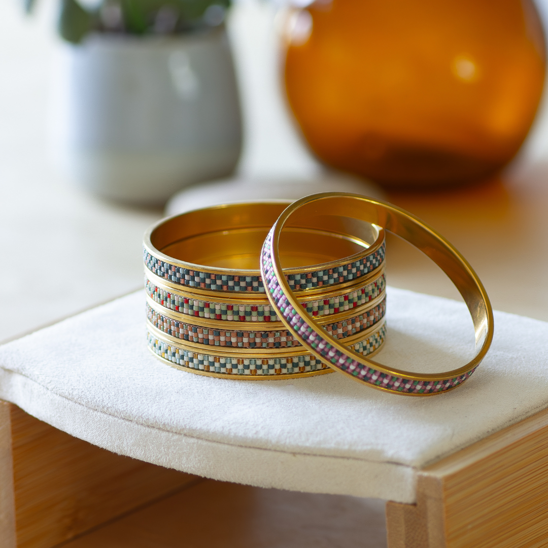 Five hand-beaded Tatreez bangles in all colourways — bubblegum pink and evergreen, marigold and sea glass, cactus green and cedar brown, fennel and orange red, and evergreen and papaya. Miyuki glass beads on 304 stainless steel.