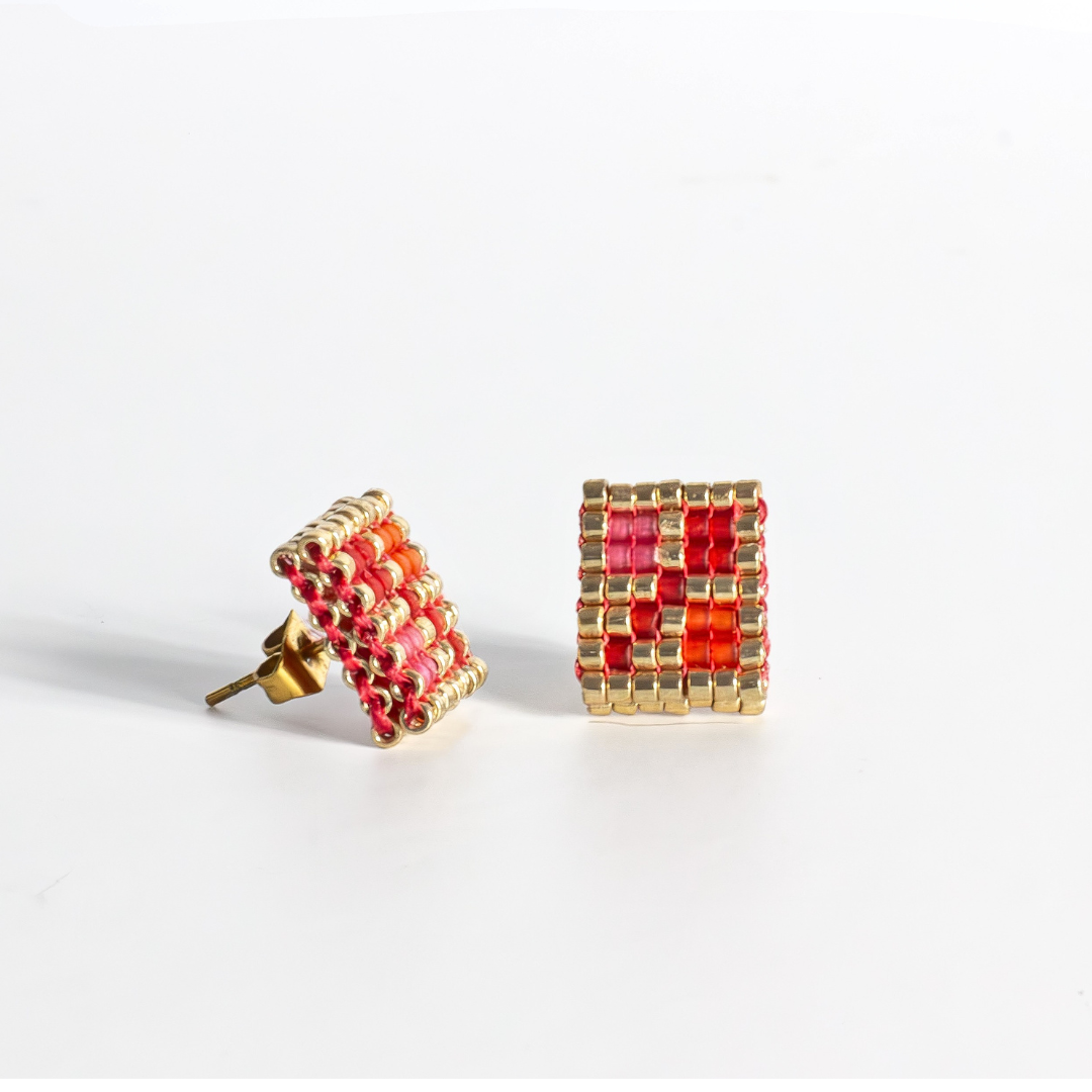 Double-faced Tatreez stud earrings in orange-red, orange, bubblegum pink, pink mist and gold on white background. Front view. Hypoallergenic gold stainless steel post.