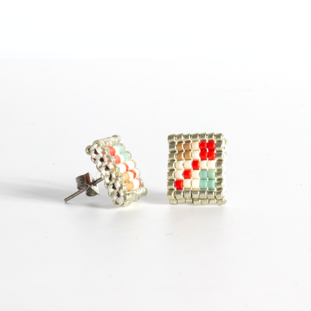 Double-faced Tatreez stud earrings in true red, silver, antique beige, sea foam and champagne on white background. Front view. Hypoallergenic silver stainless steel post.